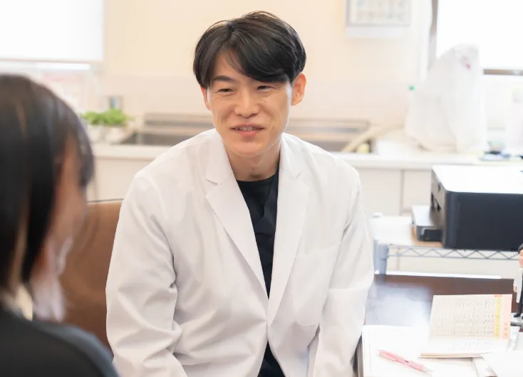 白衣の先生が、患者さんと話をしている様子