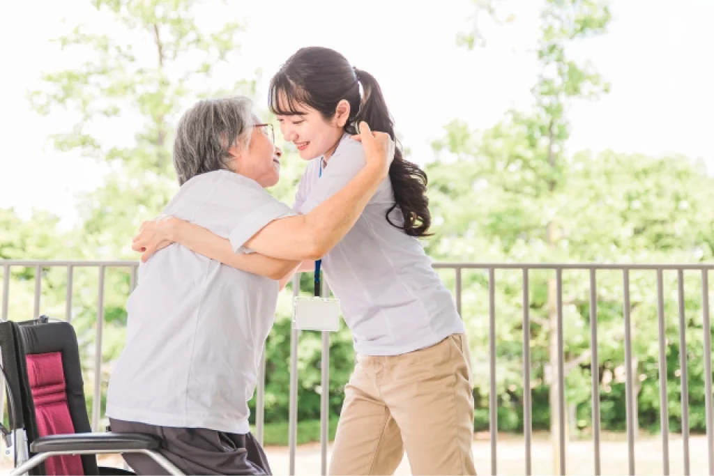 車椅子から椅子への移動を介助するスタッフ